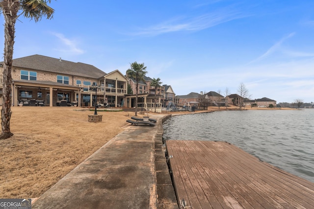 dock area with a fire pit and a water view