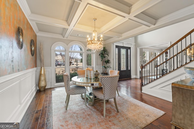 dining space featuring beam ceiling, dark hardwood / wood-style flooring, an inviting chandelier, and coffered ceiling