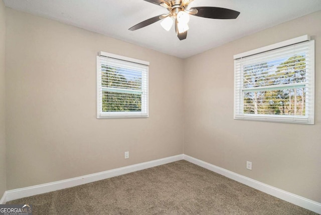 empty room with a wealth of natural light, carpet floors, and ceiling fan