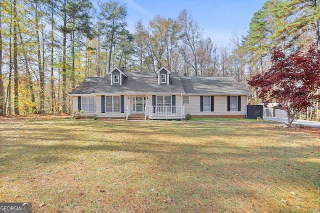 cape cod home featuring an outbuilding, a front lawn, and covered porch