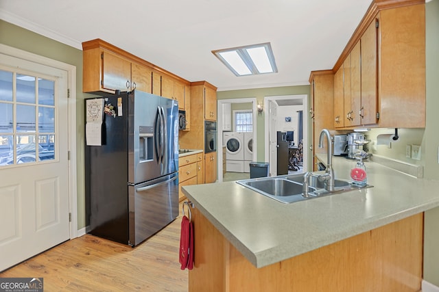 kitchen featuring stainless steel fridge with ice dispenser, light hardwood / wood-style flooring, kitchen peninsula, black oven, and washer and dryer