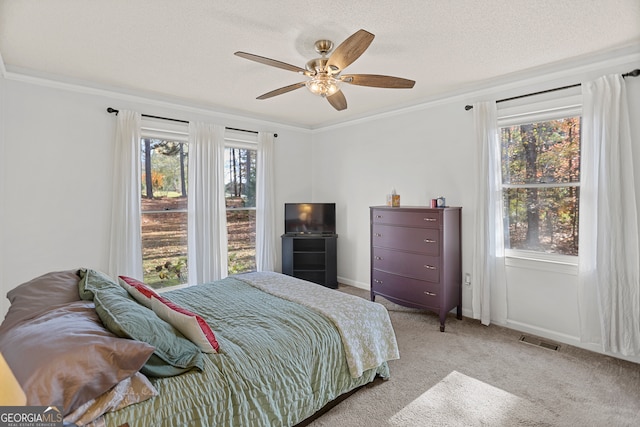 bedroom featuring ceiling fan, light colored carpet, crown molding, and multiple windows