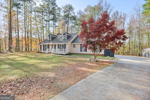 cape cod house featuring a front yard