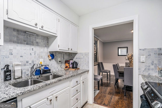 kitchen featuring white cabinets, stainless steel electric stove, sink, dark hardwood / wood-style floors, and decorative backsplash