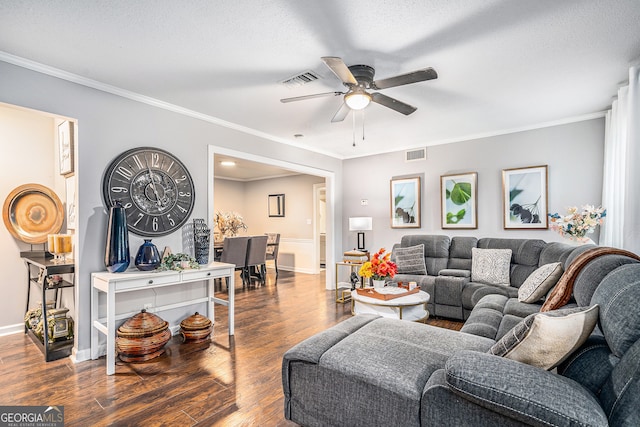 living room featuring a textured ceiling, dark hardwood / wood-style floors, ceiling fan, and crown molding