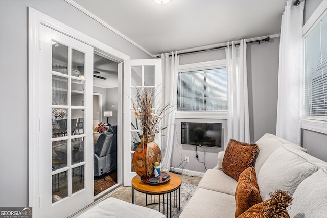 living room with ceiling fan and crown molding