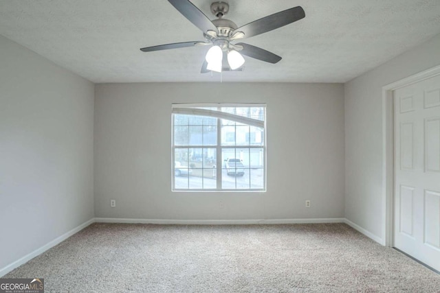 carpeted empty room featuring ceiling fan and a textured ceiling