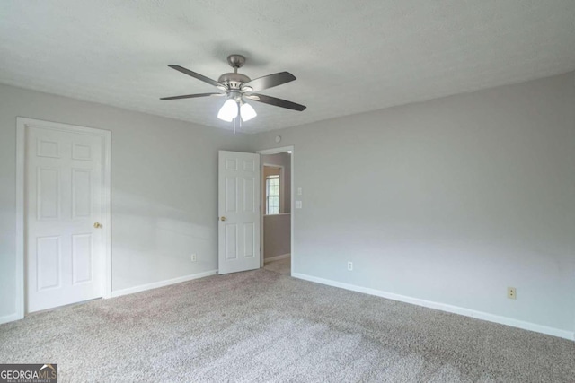 spare room featuring carpet, a textured ceiling, and ceiling fan