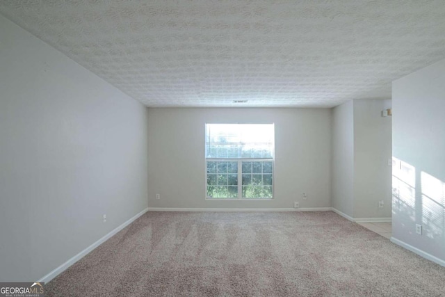 carpeted spare room with a textured ceiling