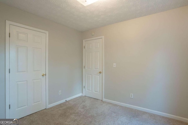 unfurnished bedroom with light carpet and a textured ceiling