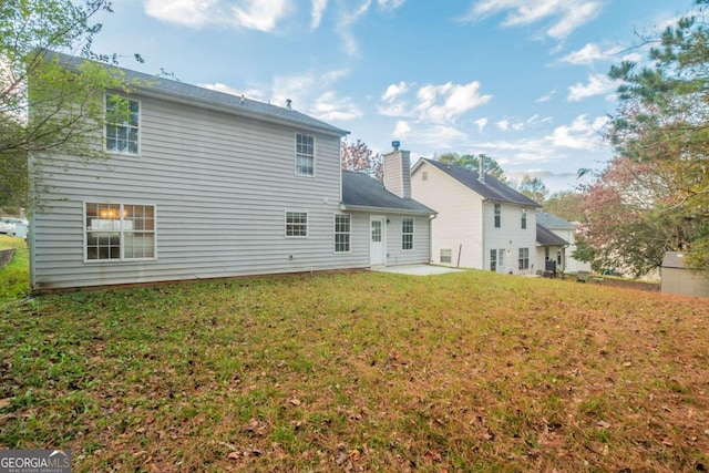 back of house with a yard and a patio