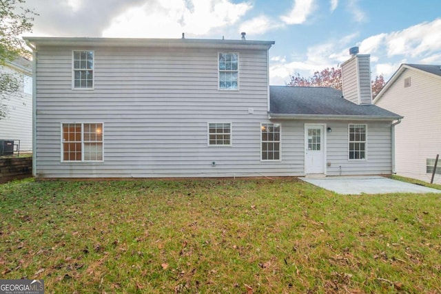 rear view of property with a lawn and a patio