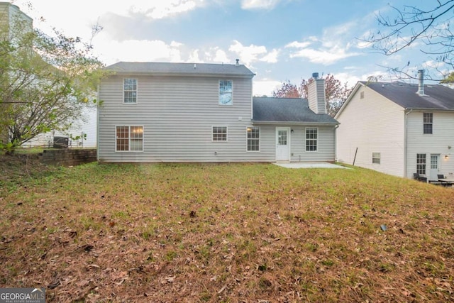 rear view of property featuring a yard, a patio, and central air condition unit