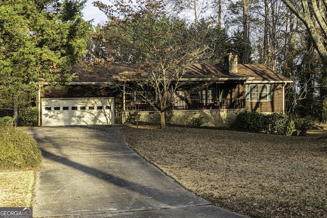 view of property hidden behind natural elements featuring a garage