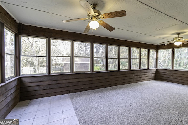 unfurnished sunroom featuring ceiling fan