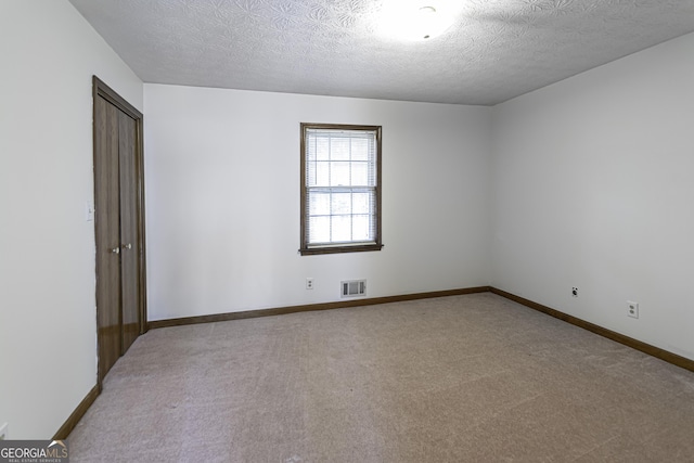 carpeted spare room featuring a textured ceiling