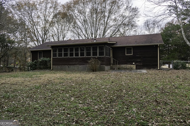 back of house with a yard and a sunroom