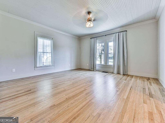 empty room with light hardwood / wood-style floors and ornamental molding