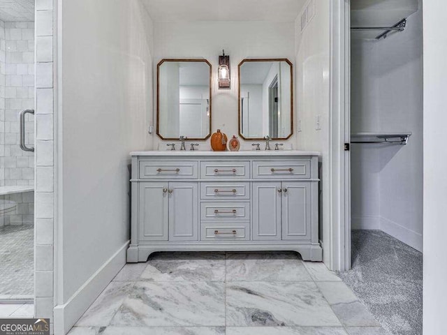 bathroom featuring a shower with door and vanity