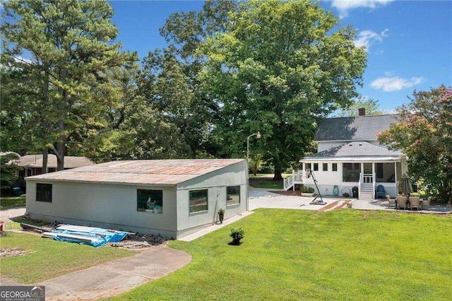 back of property featuring a yard and a patio area