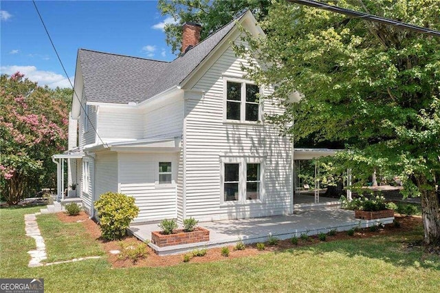 view of side of home with a yard and a patio area