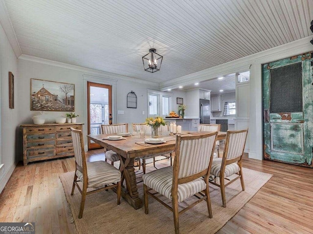 dining space with crown molding, light hardwood / wood-style flooring, wooden ceiling, and a notable chandelier