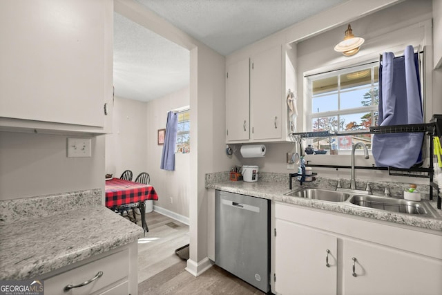 kitchen with white cabinetry, sink, light hardwood / wood-style flooring, and stainless steel dishwasher