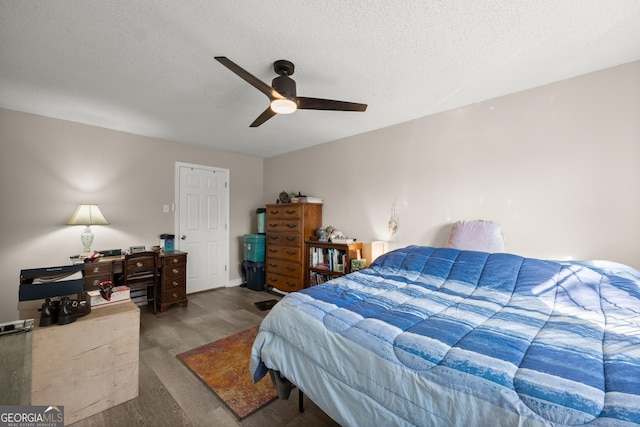 bedroom featuring ceiling fan, wood-type flooring, and a textured ceiling