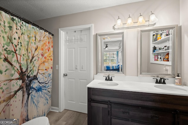 bathroom featuring vanity, hardwood / wood-style floors, and a textured ceiling