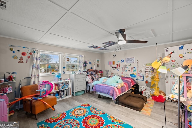 bedroom with hardwood / wood-style flooring, ceiling fan, and crown molding