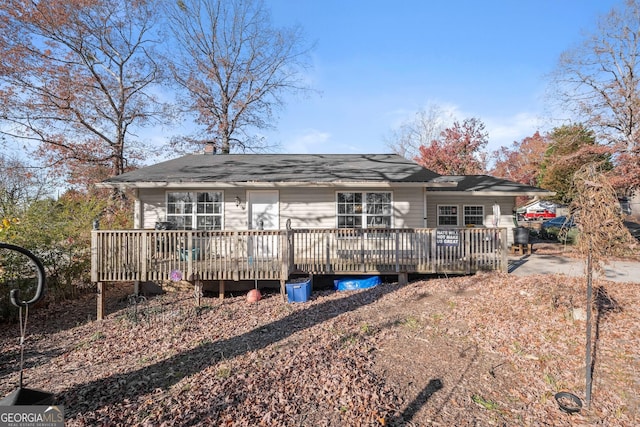 rear view of property featuring a wooden deck