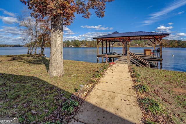 dock area with a water view and a yard