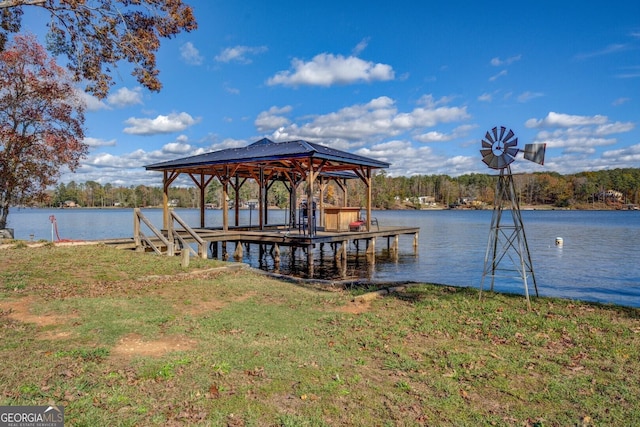 dock area with a water view and a yard