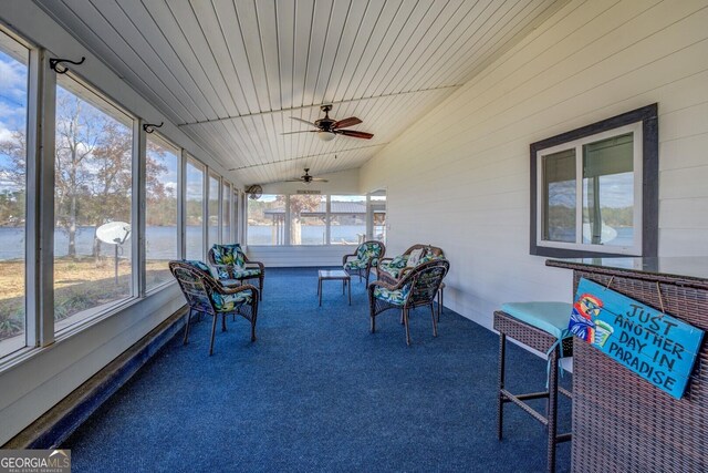 sunroom with vaulted ceiling, wooden ceiling, ceiling fan, and a water view