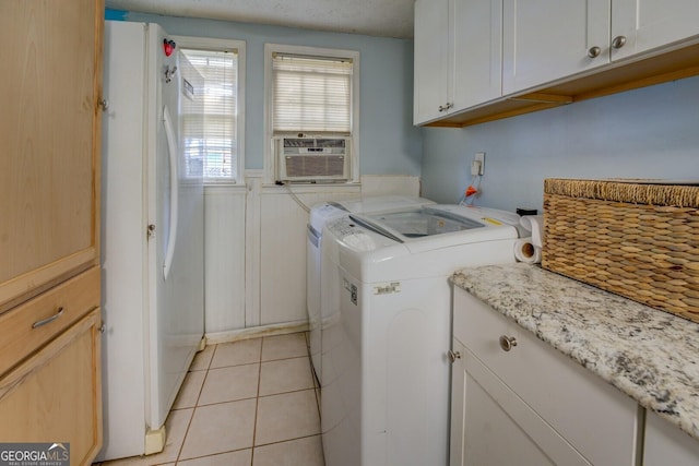 laundry area featuring cooling unit, light tile patterned floors, washing machine and dryer, and cabinets