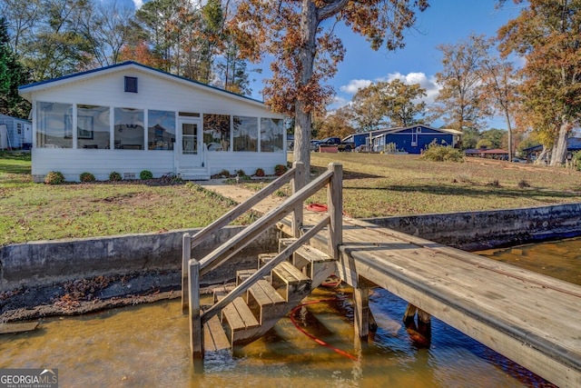 dock area with a water view and a yard