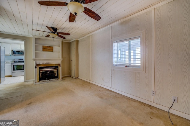 unfurnished living room featuring crown molding, light colored carpet, wood walls, and wooden ceiling