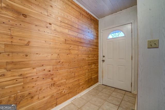 doorway to outside featuring light tile patterned flooring and wood walls