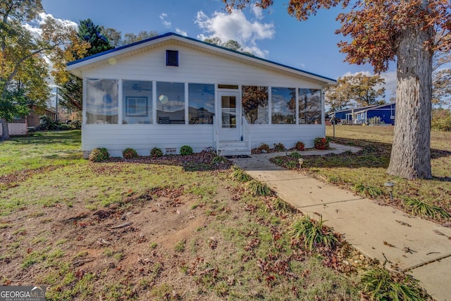 view of front of home featuring a sunroom and a front yard