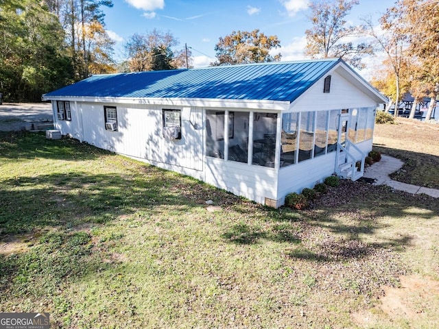 rear view of house featuring a yard and a sunroom