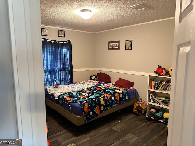 bedroom with a textured ceiling, dark hardwood / wood-style floors, and crown molding