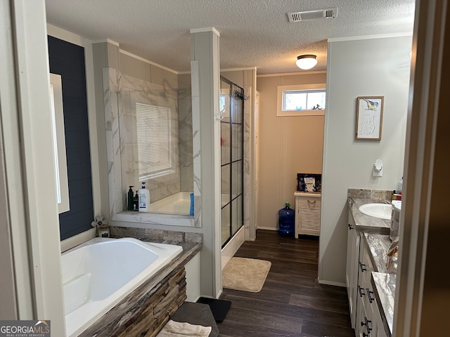 bathroom with separate shower and tub, a textured ceiling, hardwood / wood-style flooring, vanity, and ornamental molding