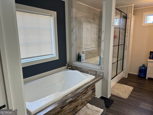 bathroom with hardwood / wood-style flooring, ornamental molding, a textured ceiling, and plus walk in shower