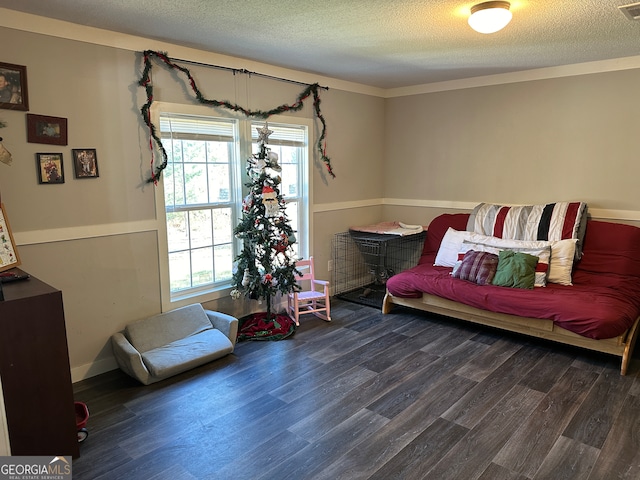 living area with crown molding, dark wood-type flooring, and a textured ceiling