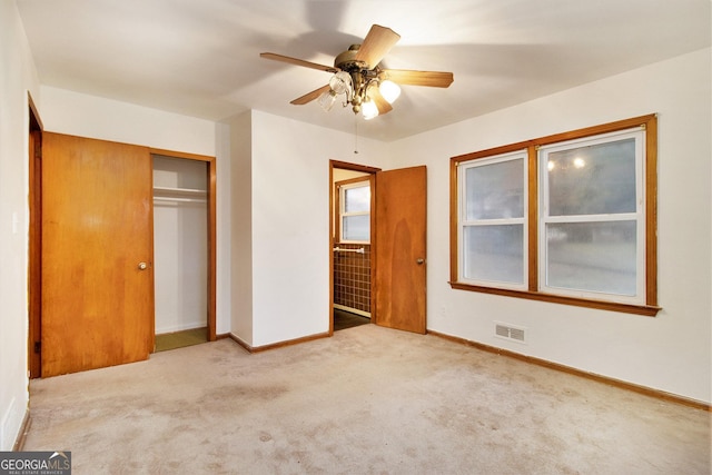 unfurnished bedroom featuring ceiling fan, light carpet, and a closet