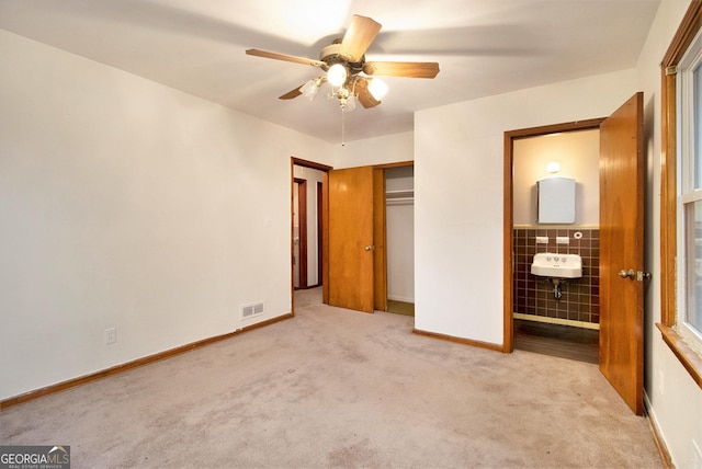 unfurnished bedroom featuring ceiling fan, light colored carpet, and a closet