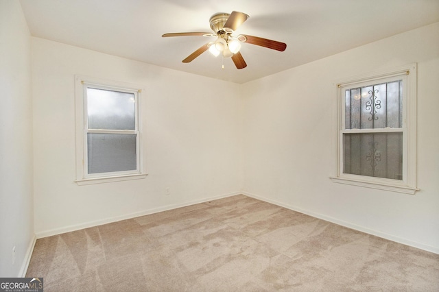 carpeted spare room with ceiling fan