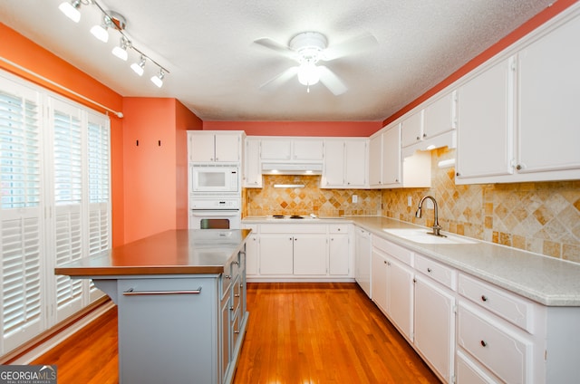 kitchen featuring light hardwood / wood-style floors, white appliances, white cabinetry, and sink