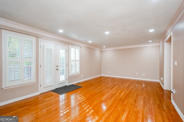 interior space with hardwood / wood-style floors, ornamental molding, and a textured ceiling