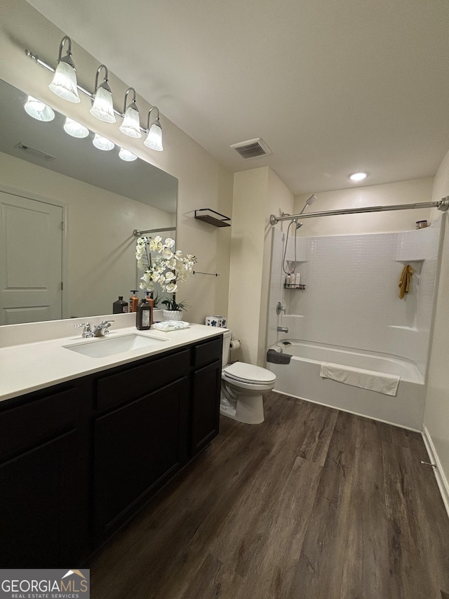 full bathroom with toilet, vanity, hardwood / wood-style floors, and tub / shower combination